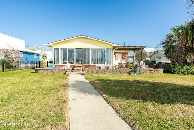 view of front facade featuring a front yard and a sunroom