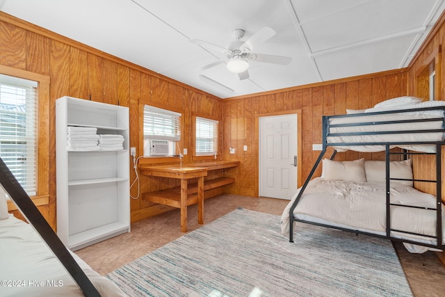 bedroom featuring wood walls, cooling unit, ceiling fan, and crown molding