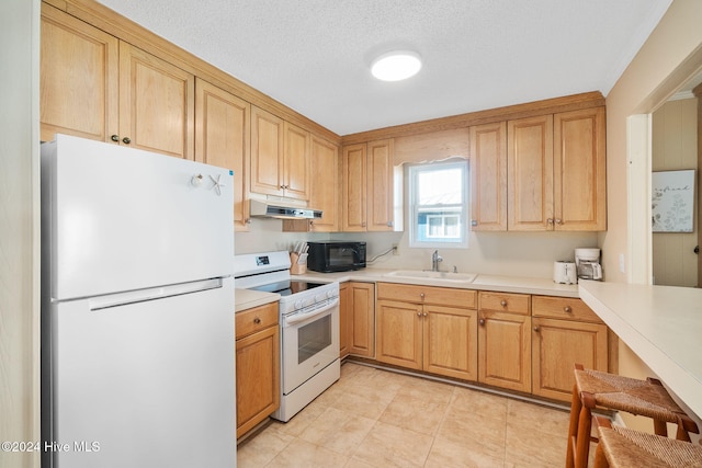 kitchen with white appliances, sink, light tile patterned floors, and a textured ceiling