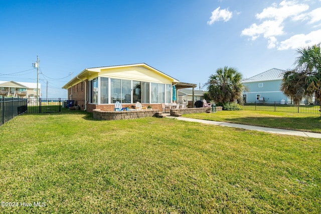 back of property with a sunroom and a yard