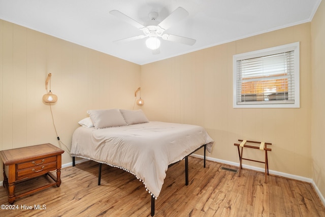 bedroom featuring ornamental molding, light hardwood / wood-style flooring, and ceiling fan