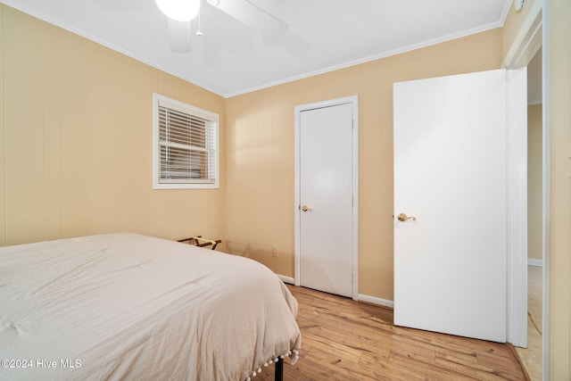 bedroom with light wood-type flooring, ceiling fan, and crown molding