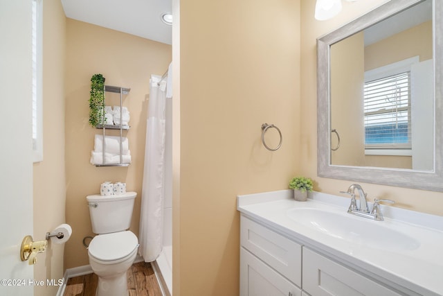 bathroom featuring curtained shower, wood-type flooring, vanity, and toilet