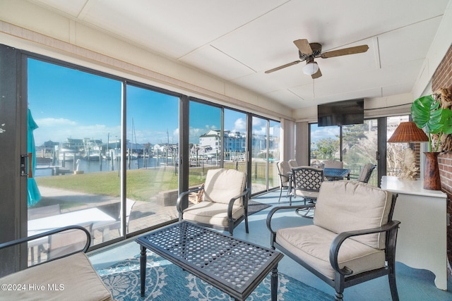 sunroom / solarium with a water view and ceiling fan