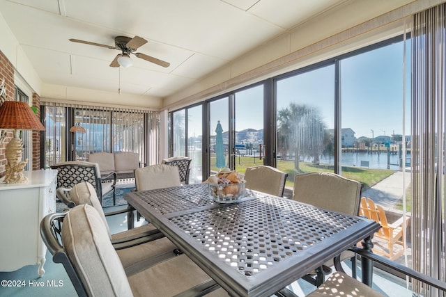 sunroom featuring plenty of natural light, a water view, and ceiling fan