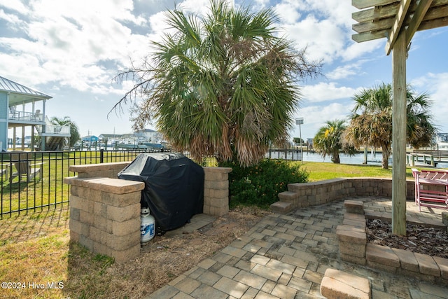 view of patio featuring area for grilling and a water view