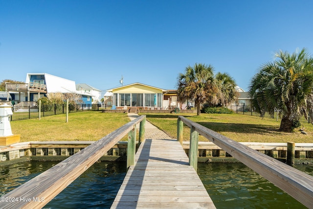 dock area featuring a water view and a lawn