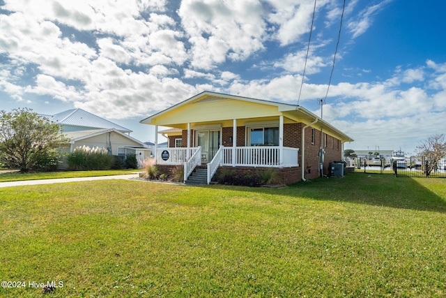 view of front of home with a front lawn, central air condition unit, and a porch