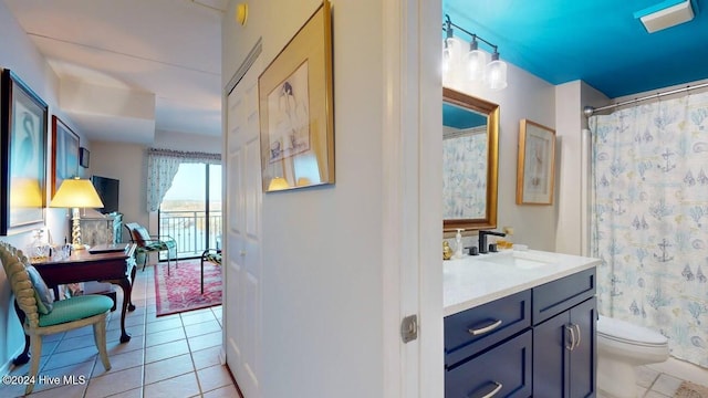 bathroom with vanity, toilet, curtained shower, and tile patterned flooring