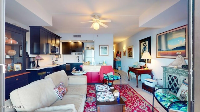 tiled living room with sink and ceiling fan