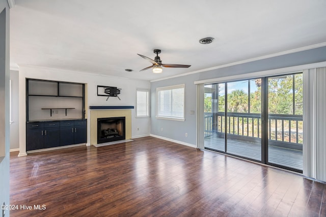 unfurnished living room with crown molding, a healthy amount of sunlight, dark hardwood / wood-style floors, and ceiling fan