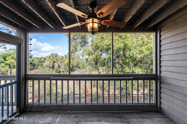 unfurnished sunroom featuring ceiling fan