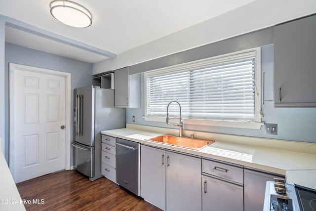 kitchen featuring stainless steel appliances, sink, dark hardwood / wood-style floors, and gray cabinets