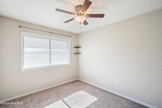 carpeted empty room featuring a textured ceiling and ceiling fan