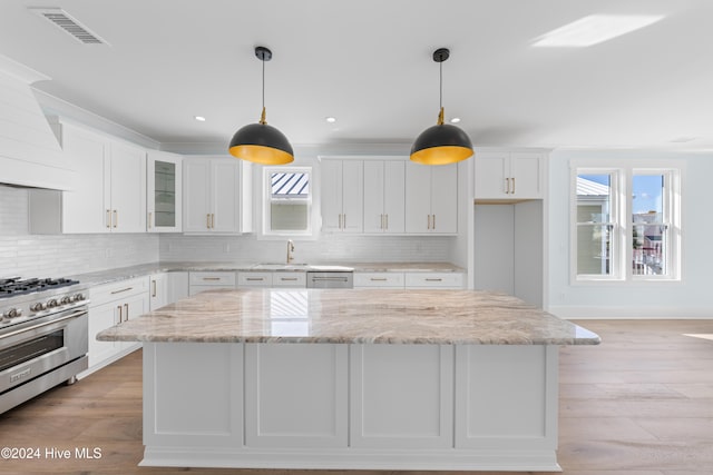 kitchen featuring appliances with stainless steel finishes, a wealth of natural light, and white cabinets