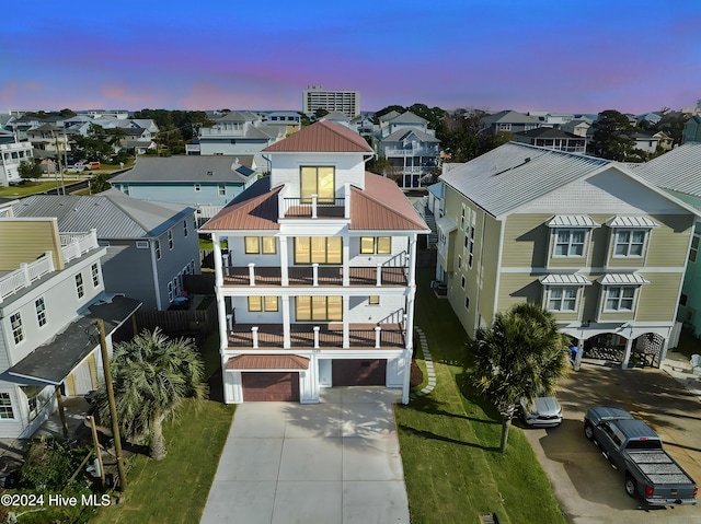1405 Pinfish Ln, Carolina Beach, NC 28428 - view of front of property featuring a balcony, a residential view, concrete driveway, an attached garage, and a standing seam roof
