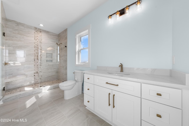 bathroom with toilet, a shower with shower door, and vanity