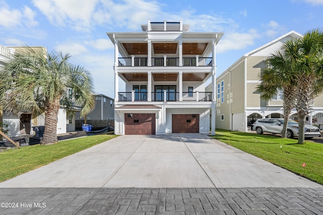 beach home with a balcony, a front yard, and a garage