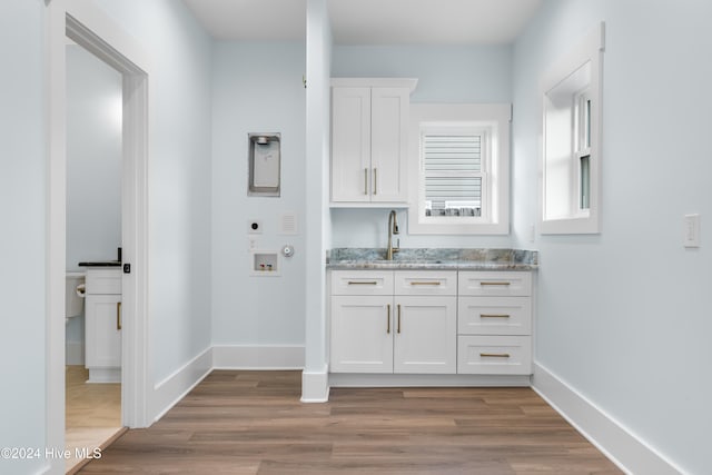 laundry room featuring cabinets, hookup for a washing machine, hardwood / wood-style flooring, and electric dryer hookup