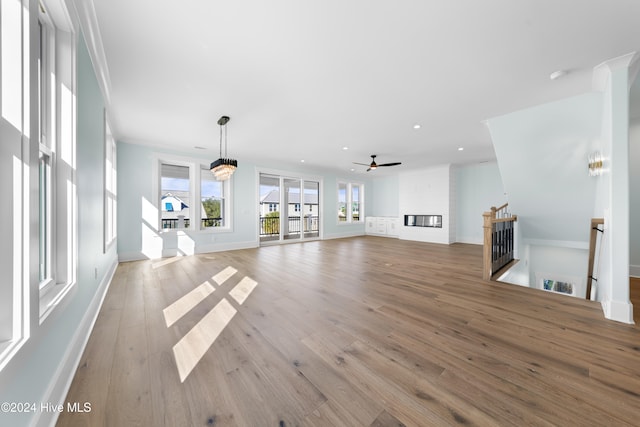 unfurnished living room with ceiling fan and light wood-type flooring