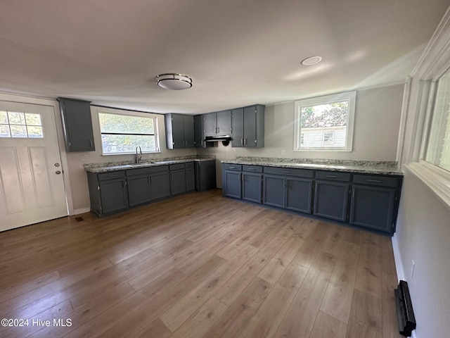 kitchen featuring sink, light stone counters, and light hardwood / wood-style floors