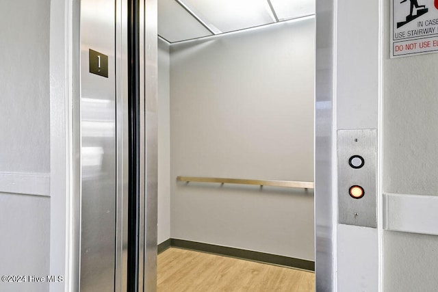 details featuring elevator and hardwood / wood-style floors