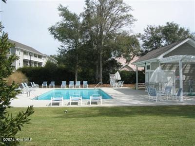 view of swimming pool featuring a patio area and a lawn