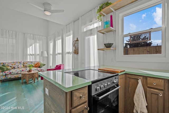 kitchen with high end range, kitchen peninsula, and ceiling fan