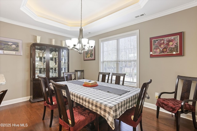 dining area featuring a tray ceiling, crown molding, dark hardwood / wood-style floors, and a notable chandelier