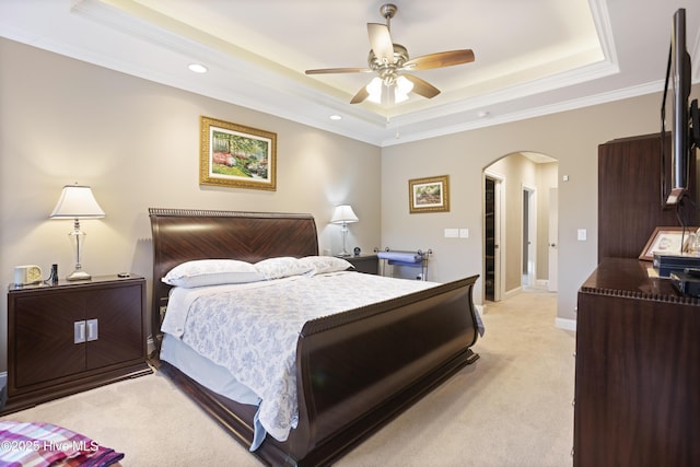 carpeted bedroom featuring ceiling fan, ornamental molding, and a tray ceiling