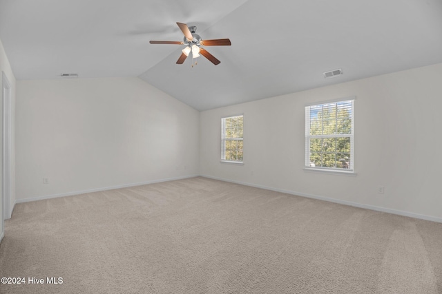 unfurnished room featuring ceiling fan, light colored carpet, and lofted ceiling