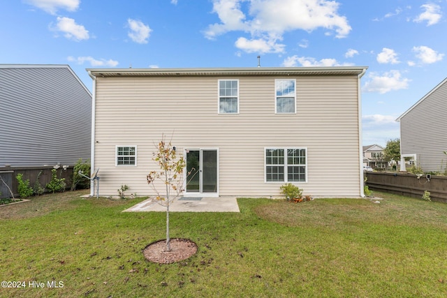 rear view of house featuring a lawn and a patio area