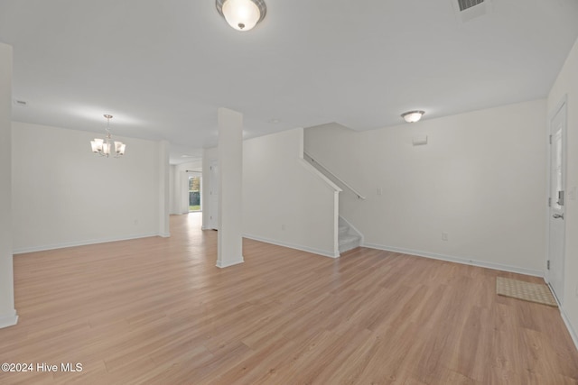 414 Louisia Mae Way, New Bern, NC 28560 - unfurnished living room featuring light wood-type flooring, stairs, a chandelier, and baseboards