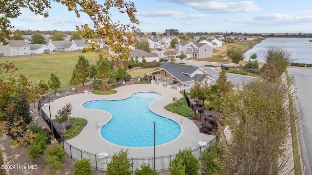 view of pool with a water view and a patio