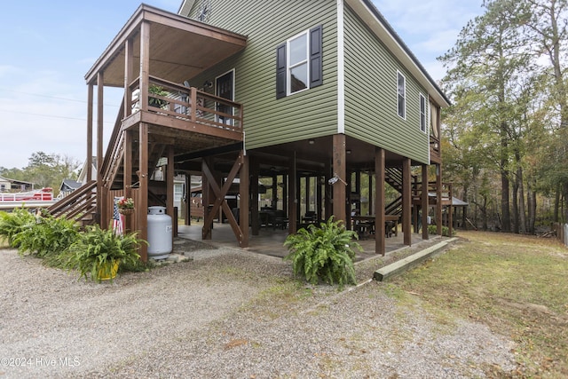 rear view of property with a deck and a patio area