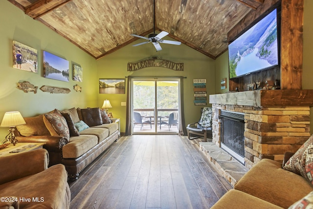 living room featuring a stone fireplace, ceiling fan, beamed ceiling, and dark wood-type flooring