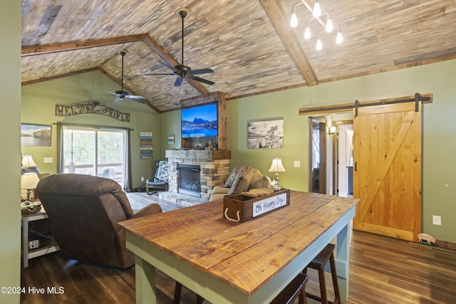 dining space featuring vaulted ceiling with beams, a barn door, dark hardwood / wood-style flooring, and a fireplace