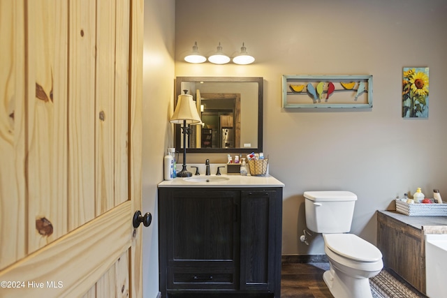 bathroom with vanity, hardwood / wood-style flooring, and toilet