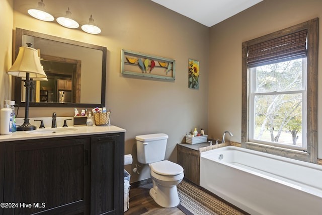 bathroom with hardwood / wood-style floors, a bathtub, toilet, and vanity