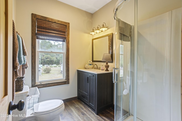 bathroom with wood-type flooring, vanity, toilet, and an enclosed shower