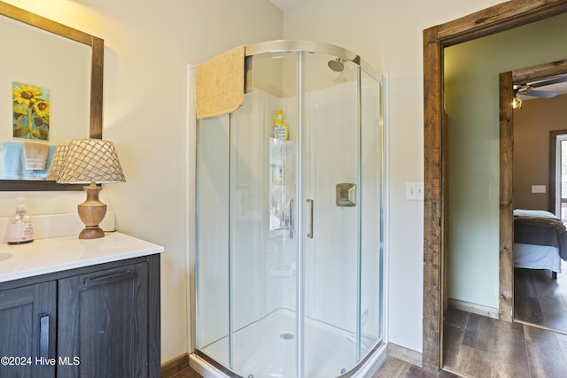 bathroom with hardwood / wood-style floors, vanity, and walk in shower