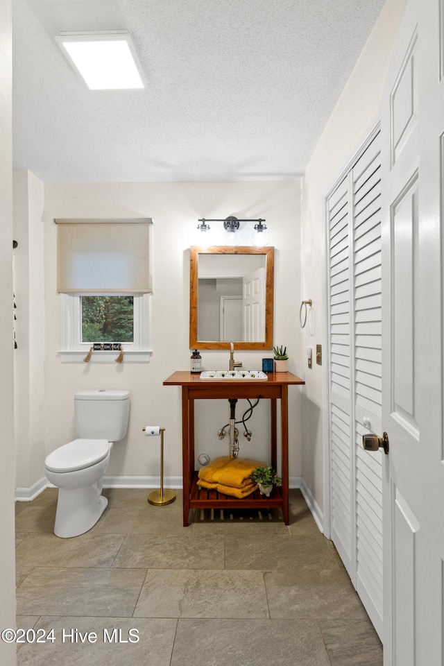 bathroom with a textured ceiling and toilet