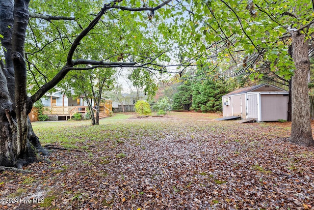 view of yard featuring a wooden deck and a shed