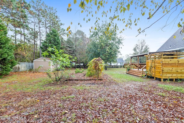 view of yard featuring a storage unit and a deck