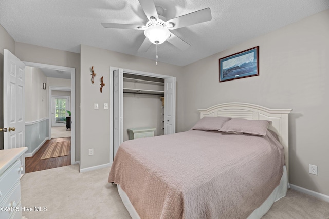 212 Outrigger Rd, New Bern, NC 28562 - bedroom featuring a closet, light colored carpet, a textured ceiling, a ceiling fan, and baseboards