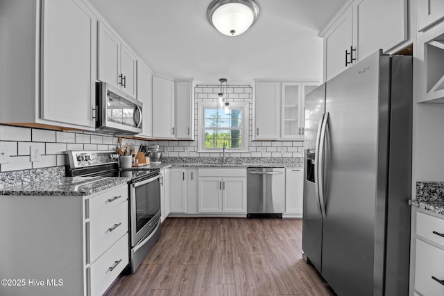 212 Outrigger Rd, New Bern, NC 28562 - kitchen with appliances with stainless steel finishes, white cabinetry, decorative backsplash, dark wood finished floors, and stone countertops