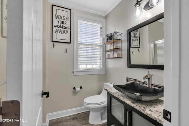 bathroom with ornamental molding, vanity, hardwood / wood-style flooring, and toilet