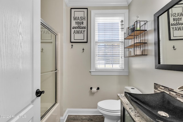 full bathroom featuring shower / bath combination with glass door, vanity, toilet, and crown molding