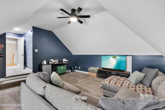 carpeted cinema room with ceiling fan and vaulted ceiling