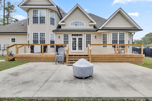 rear view of property with a wooden deck and a patio